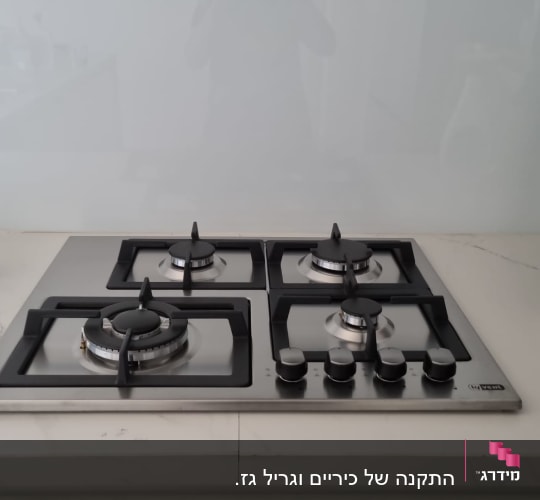 כיריים גז עם ארבעה מבערים וכפתורי שליטה